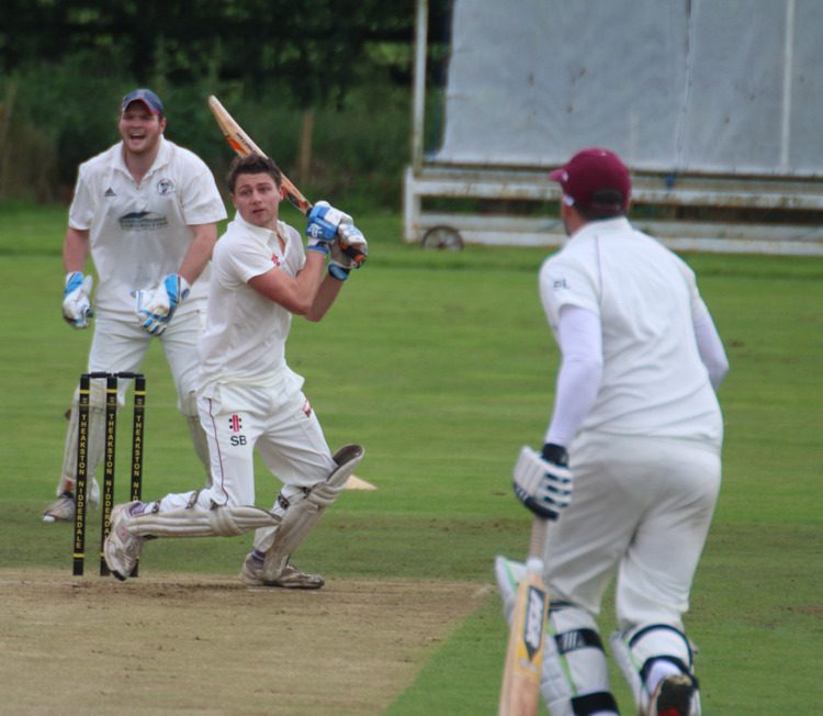 batsman hits to mid-off watched by the wicketkeeper